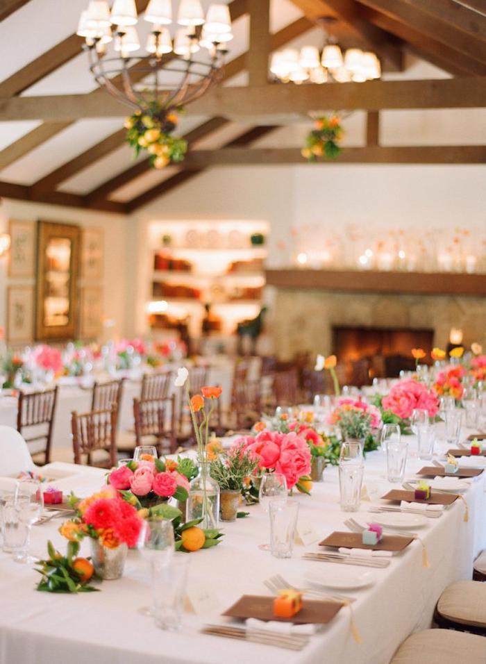 centre de table en fleurs rose et fuchsia et clementines, branches de citron suspendues, idee decoration mariage colorée en couleurs vitaminées
