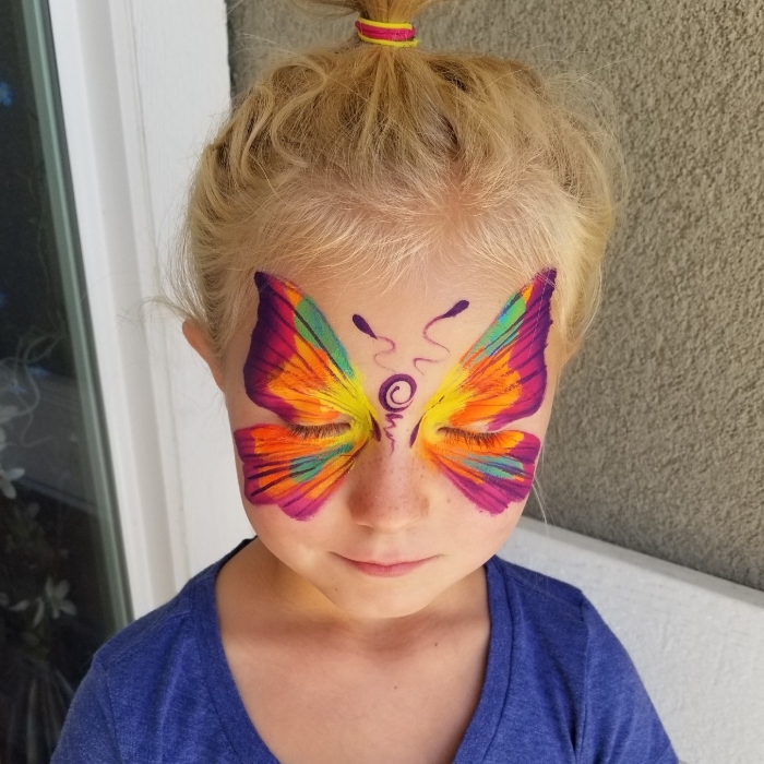 idée de maquillage carnaval facile à réaliser avec un pochoir de papillon et peinture faciale de différentes couleurs