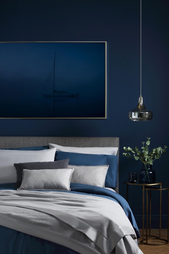 exemple de deco chambre parentale contemporaine aux murs bleu nuit aménagée avec lit gris et meuble de chevet métal