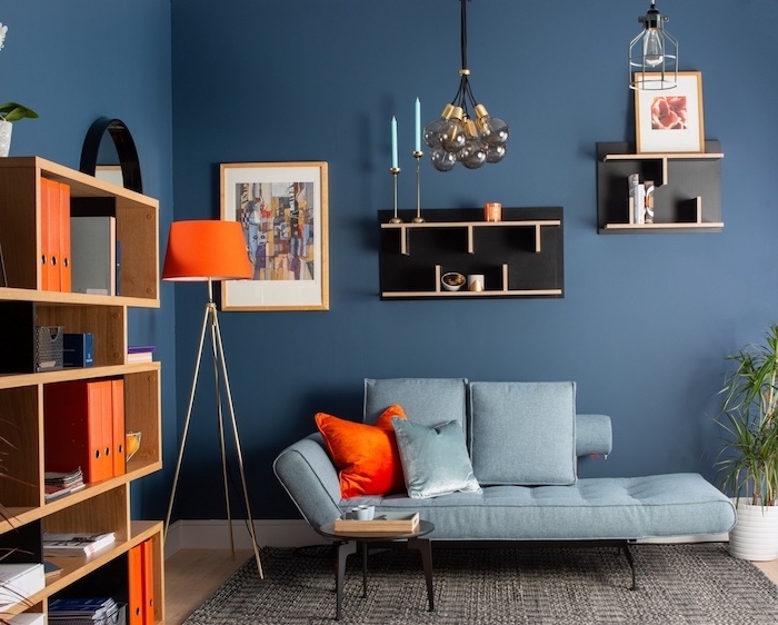deco maison contemporaine avec salon bleu nuit aux accents orange, coussin, lampe orange, étagère originale couleur noire, suspension boules de verre