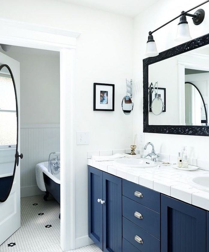 modele salle de bain épurée en blanc et bleu pantone, plan de travail carrelage blanc, miroir avec cadre noir, éclairage miroir, murs blancs