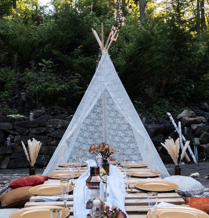 tente indienne dentelle blanche et table basse de bois et des assiettes or, centre de table vole blanche, lanterne