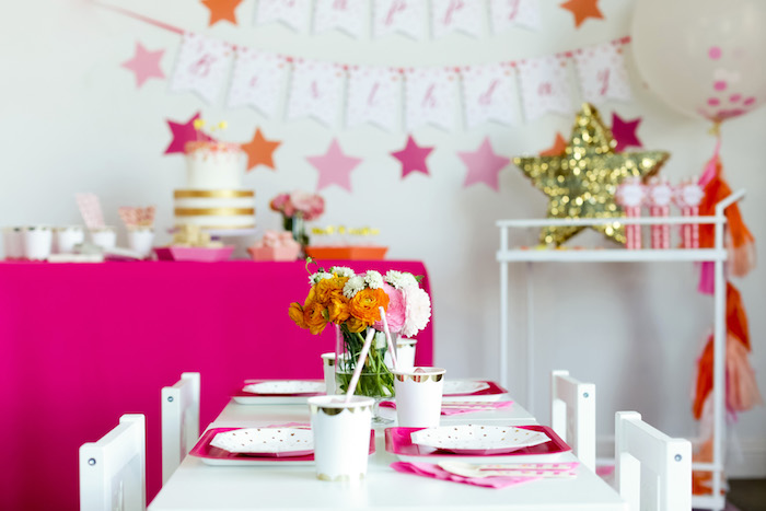 decoration salle anniversaire fuchsia et blanc, centre de table anniversaire floral, deco etoiles rose, accents dorés