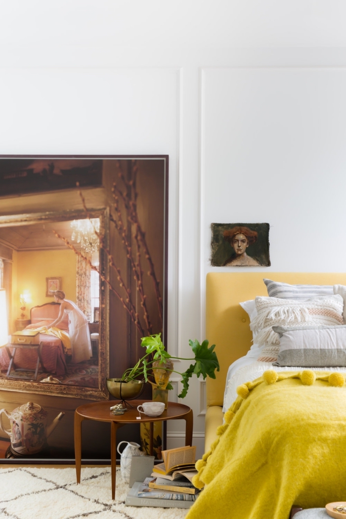 idée déco chambre adulte aux murs blancs et parquet bois clair avec grand lit à tête tissu jaune et éléments de style retro