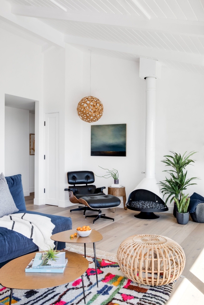 salon blanc au parquet bois clair aménagé avec canapé bleu et table de salon double plateau en bois et fer noirci, deco salon moderne