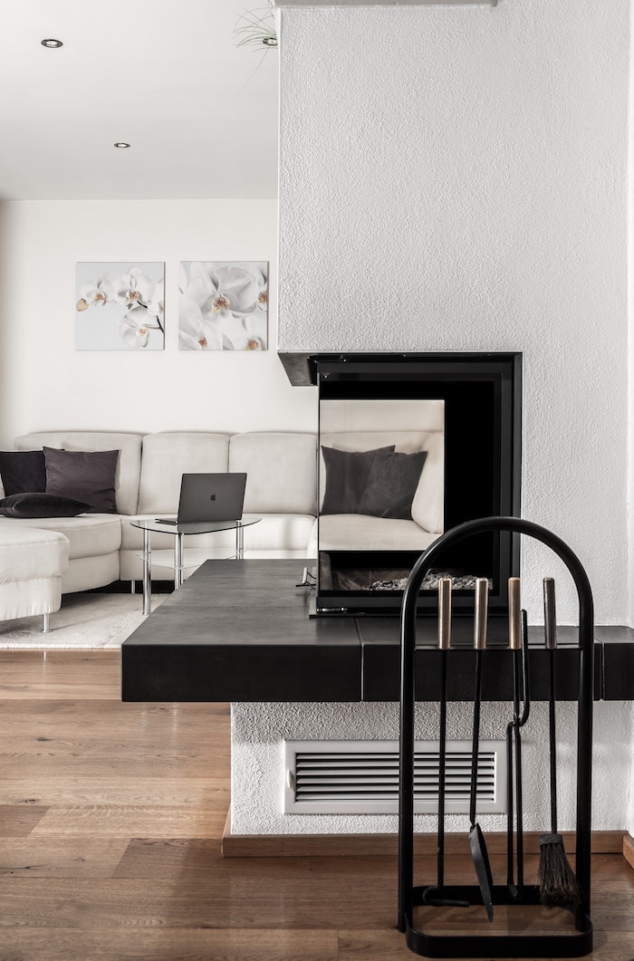 Noir et blanc salle de séjour avec cheminée transparente, idée canapé blanc en angle, table basse en verre