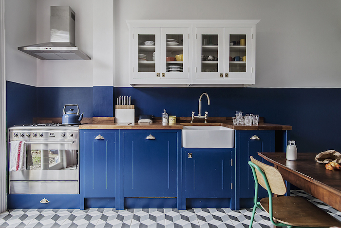 deco cuisine vintage avec meuble cuisine bleu nuit et peinture murale bleu et blanc meuble haut blanc, carrelage gris et blanc, table bois brut