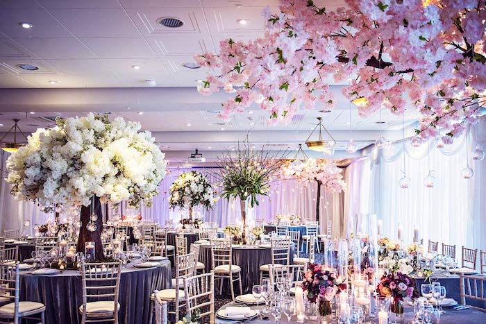 riche décoration florale de fleurs blanches et roses, nappes grises sur table et rideaux blancs, bougies decorative,theme mariage floral