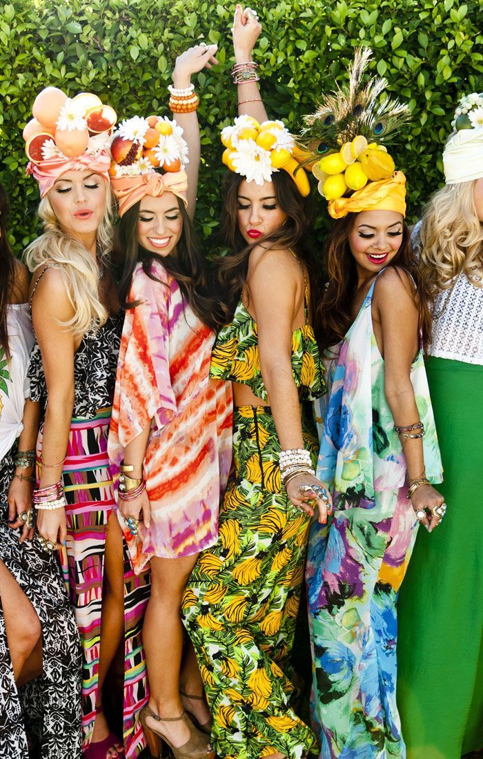 thème de soirée tropical autour de la piscine, femmes en robes colorées et accessoires cheveux en fleurs et fruits tropicaux