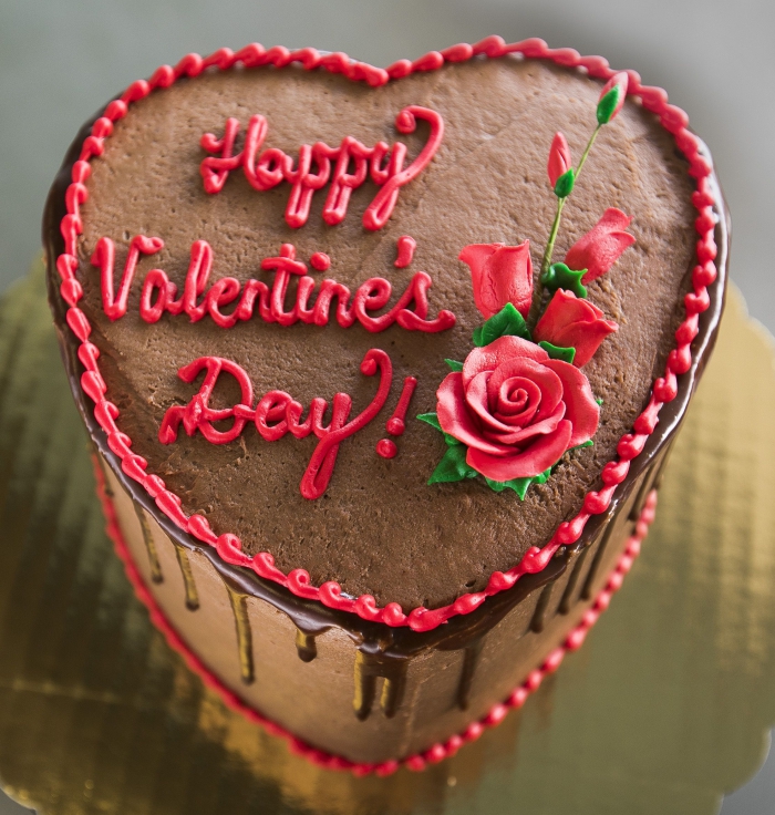exemple de gateau coeur au caramel et chocolat noir avec décoration Joyeuse Saint Valentin et petits fleurs rouges
