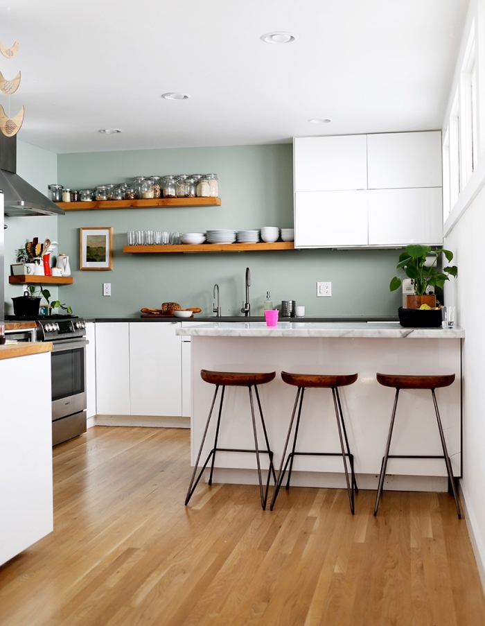 idée comment décorer une cuisine aux murs de nuance vert celadon avec meubles blanc et accents en bois foncé