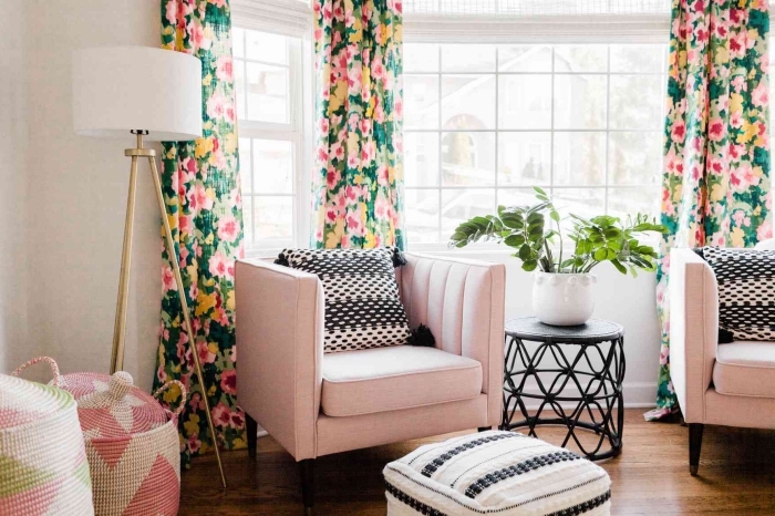 deco salon moderne aux murs blancs et sol en bois foncé aménagé avec meubles en tissu rose pastel et accents noir mat