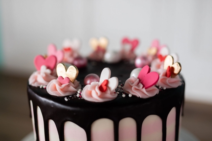 exemple comment décorer un gâteau romantique au chocolat noir avec coeurs comestibles et mini fleurs en crème rose