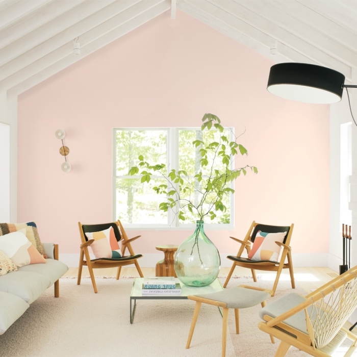 comment aménager une salle de séjour moderne aux murs roses avec meubles en bois et coussins multicolore