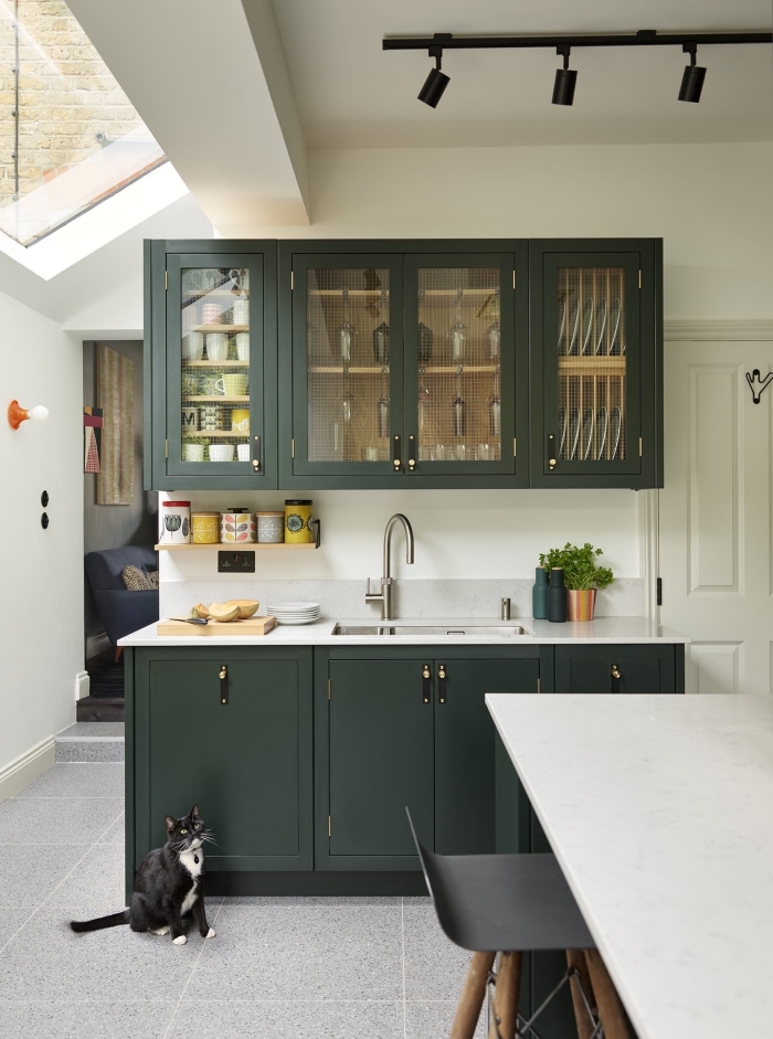 modèle de petite cuisine blanche avec crédence en carrelage gris clair et meubles de nuance vert de gris à poignées noires