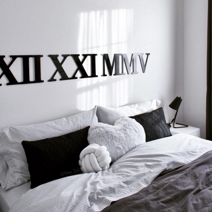 exemple de chambre gris et blanc décoré de style hygge avec grand lit couvert de coussins décoratifs en noir et gris