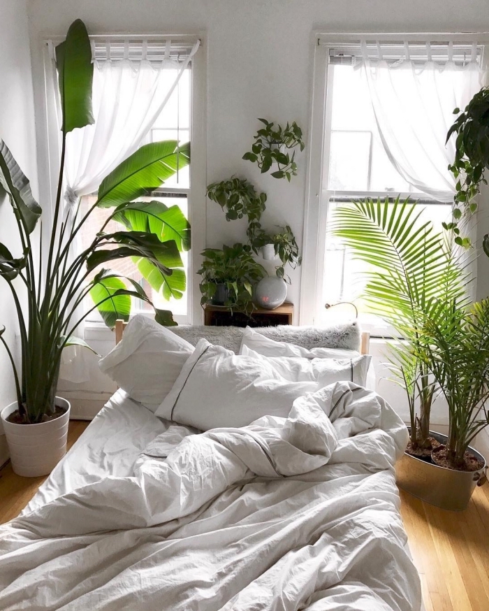 petite chambre à coucher décorée de style bohème et jungalow avec plantes vertes et un grand lit cocooning