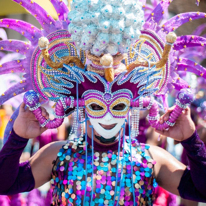 Masque de carnaval, homme habillée en paillettes colorés, carnaval de changement des roles