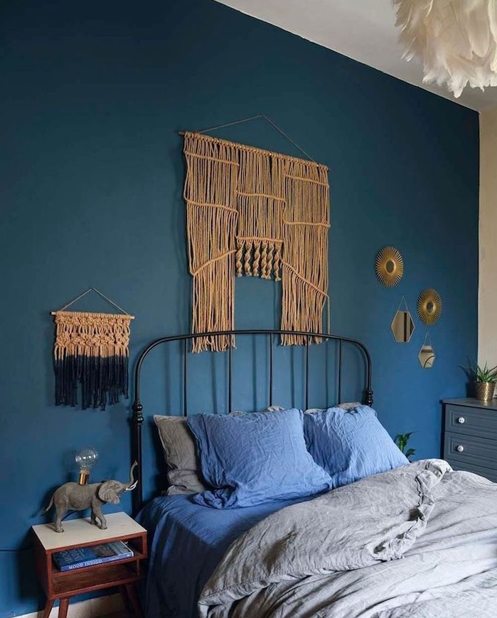 mur de fond de couleur bleu et tete de lit macramé mural dans chambre à coucher gris et bleu, suspension blanche à plumes