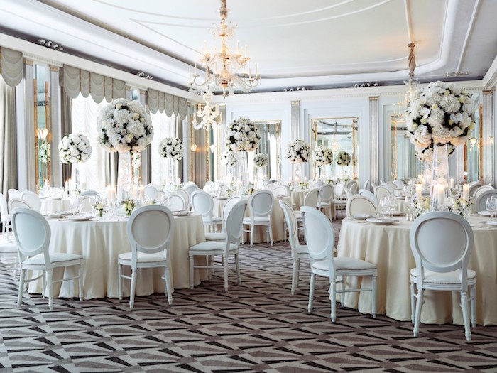 nappes, chaises et fleurs blanches pour décorer une salle de mariage élégante avec tapis marron, noir et gris