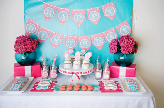 candy bar thème spa en rose et bleu avec des bouquets de fleurs fuchsia, cupcakes, macarons, biscuits décorés