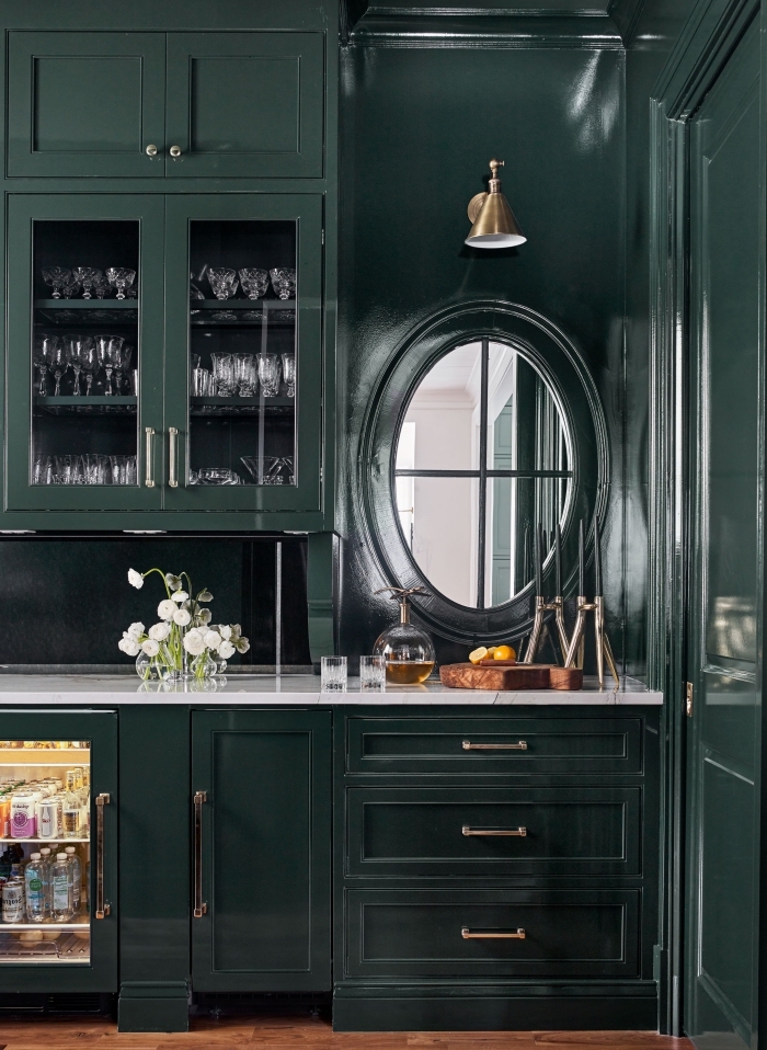 design moderne dans une cuisine à peinture vert foncé aménagée avec meubles foncés et plan de travail blanc