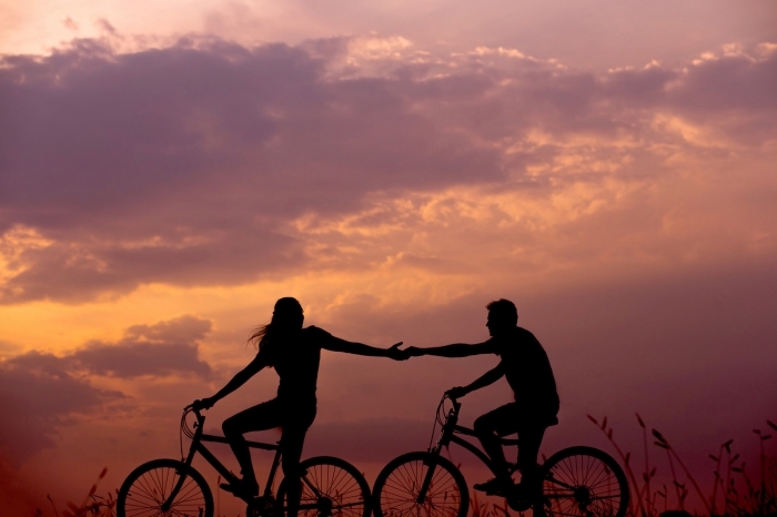 idée amusante d'activité en amoureux, se promener à vélo dans la nature au coucher de soleil en couple amoureux