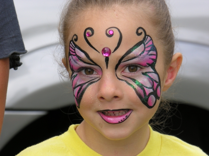 technique dessin de masque deguisement simple avec kit de peinture faciale pour enfant, modèle papillon rose et noir sur visage fille