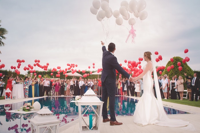 Couple marié, robe de mariage sirène, ballons blanches et rouges, soirée de mariage extérieur autour de la piscine