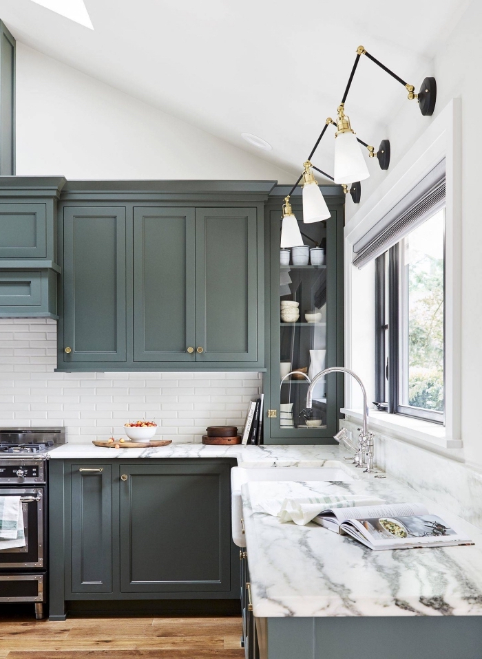 modèle de cuisine stylée aux murs blancs avec crédence carreaux blancs aménagée avec meubles de nuance vert de gris