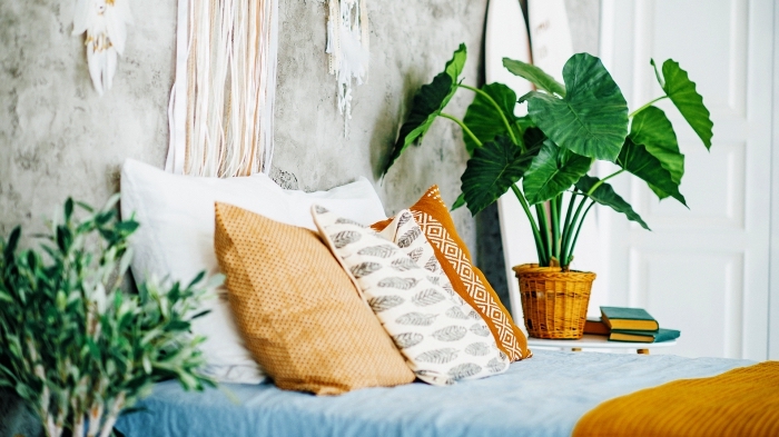 idée de déco de lit bohème chic avec coussins orange et blanc à motifs ethniques, décoration murale avec attrape-rêve