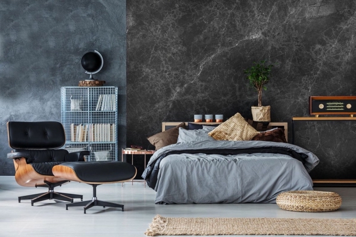 deco chambre adulte aux murs foncés à effet marbre gris et sol blanc avec meubles en bois marron et cuir noir