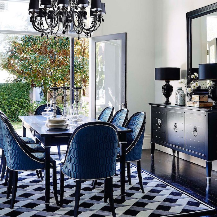 tapis noir, gris et blanc dans salle à manger vintage, table et chaises bleues, commode bleue, lustre elegant