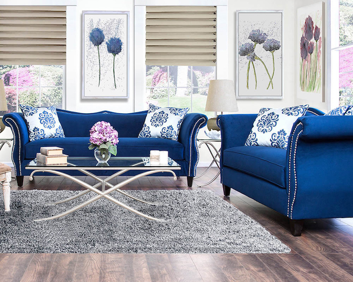modele de canapé bleu nuit dans salon avec deco de cadres à motif fleur, tapis gris moelleux sur parquet salon