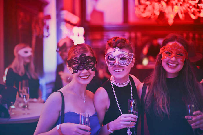 thème déguisement anniversaire bal masqué, femmes en robe de soirée chic et glamour et des masques de carnaval