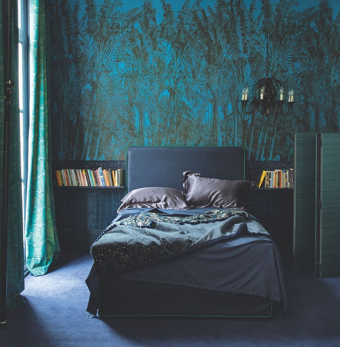 papier peint bleu à imprimé jungle dans une chambre à coucher gris et bleu avec rideaux verts et tapis bleu, lustre noir elegant
