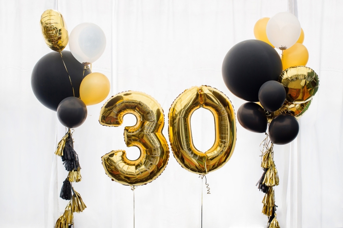 style-deco-noir-et-or-célébration-élégant-décor-ballons-noirs-chiffres-30-ans-or-surprise-anniversaire-femme-avec-ballons exemple de deco anniversaire noir et or avec ballons en hélium, idées quelles couleurs combiner pour une fête stylée