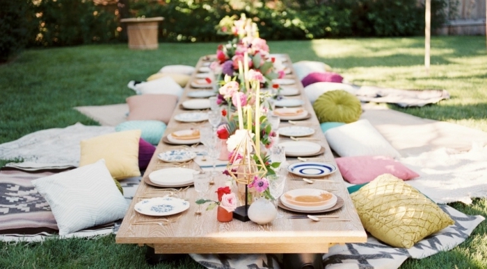 deco 30 ans de style bohème chic, organiser un party d'anniversaire dans le jardin avec table bois pique-nique et coussins décoratifs