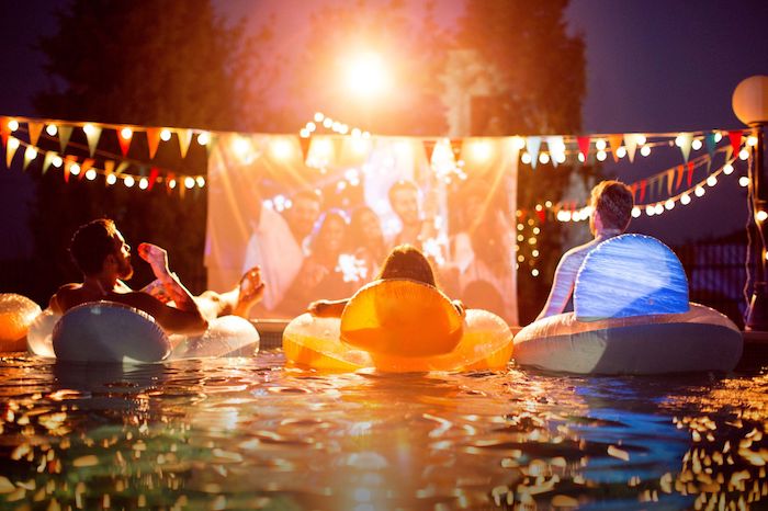 soirée cinéma piscine avec panneau cinéma et guirlande à fanions, idée thème soirée insolite