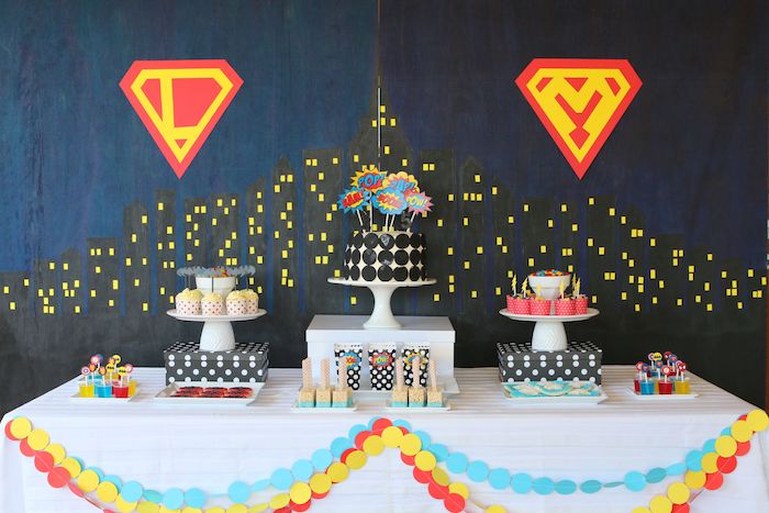 thème déguisement soirée superhéro avec fond noir et bleu marine, candy bar à cupcakes et gateau original