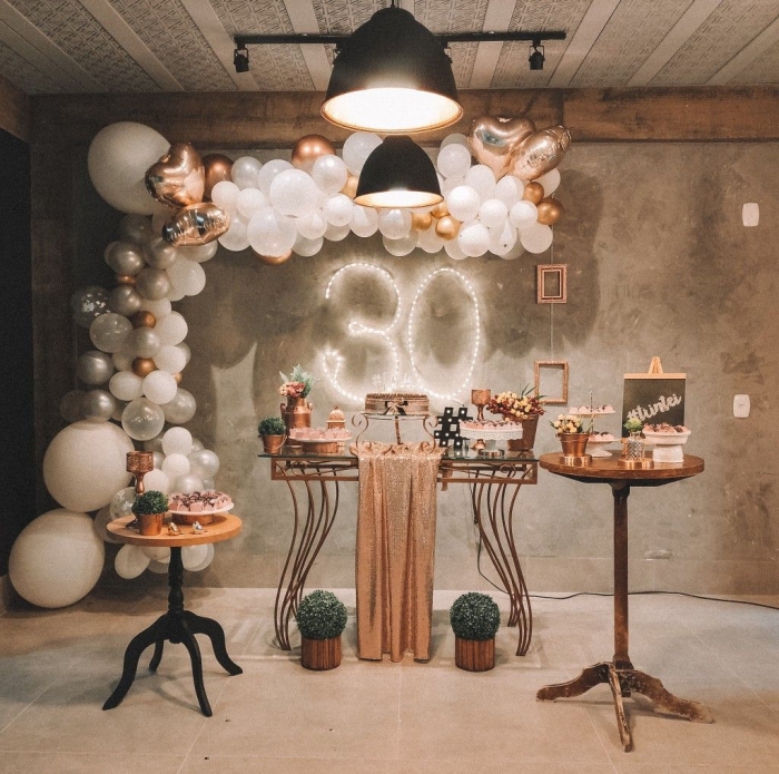 décoration pour une fête d'anniversaire 30 ans femme, pièce aux murs béton décorée avec ballons en blanc et rose gold pour un party 30 ans