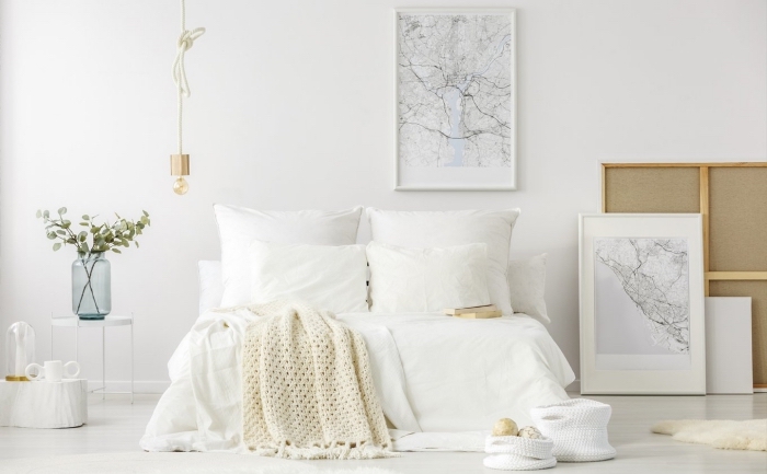 design intérieur scandinave dans une pièce spacieuse aux murs blancs aménagée avec grand lit cocooning à tête de lit bois