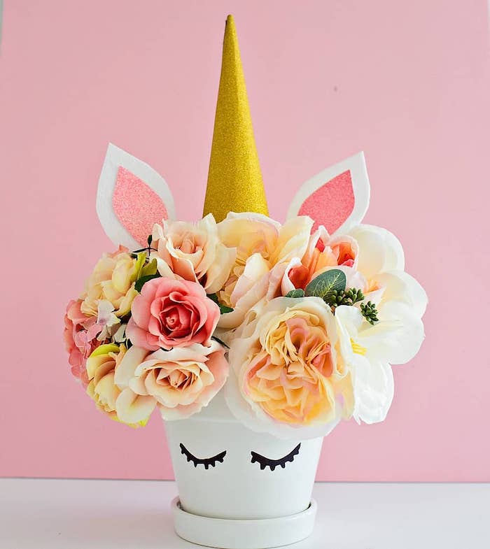 exemple de motif deco licorne sur un pot de fleur blanc, corne de papier or paillette, fleurs colorées, cache pot recup original