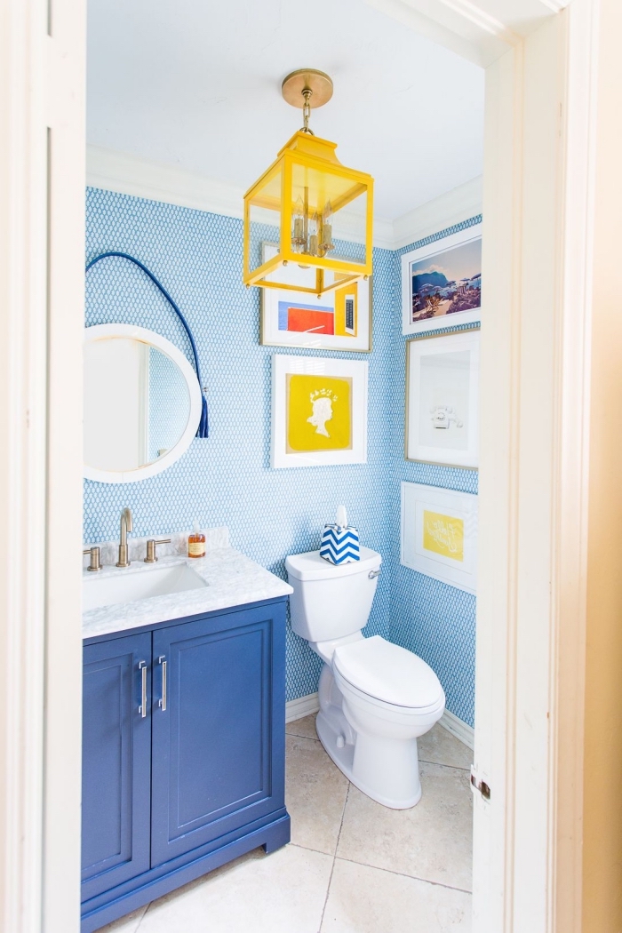 agencement salle de bain petit espace, décoration toilette aux murs bleus avec meubles colorés, décoration murale avec cadres photos