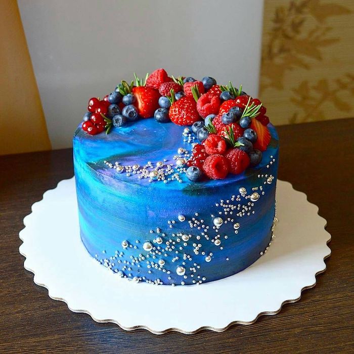 decoration de fruits rouges, fraises, framboises et myrtilles en arc sur cake gaalxy décoré de perles billes blanches et grises