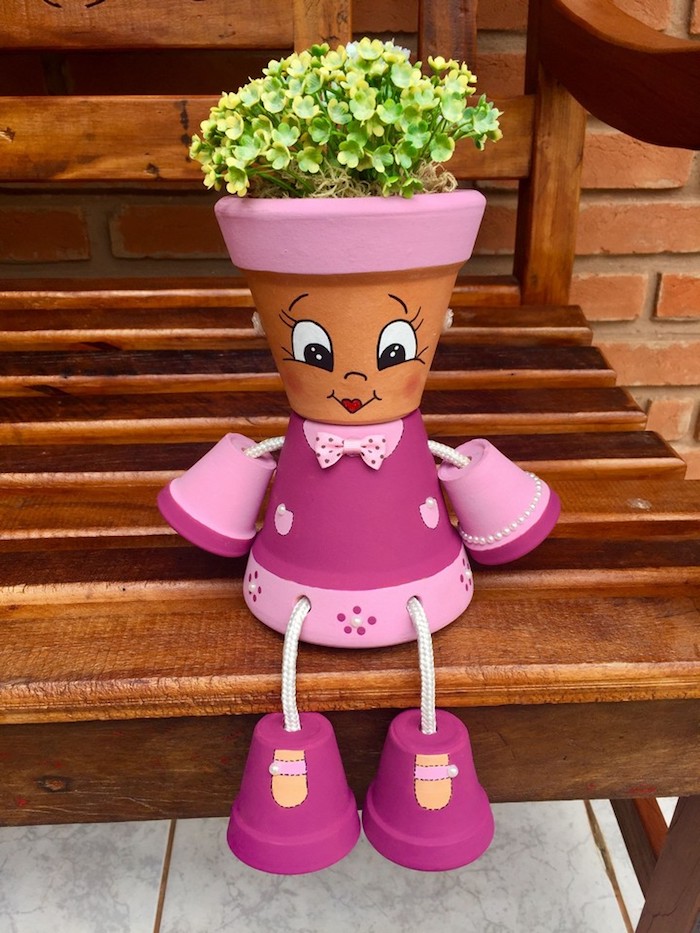 fabriquer des personnages avec des pots de fleurs en rose clair et foncé avec dessin traits de visage sur pot et plante verte a l interieur