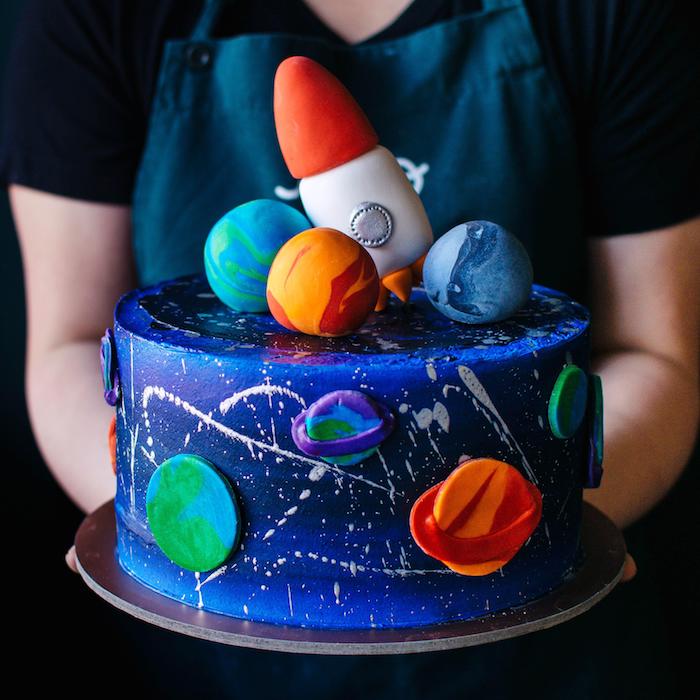 modele gateau d anniversaire au glácage bleu violet et figurines p6ate à sucre imitant les planètes du système solaire