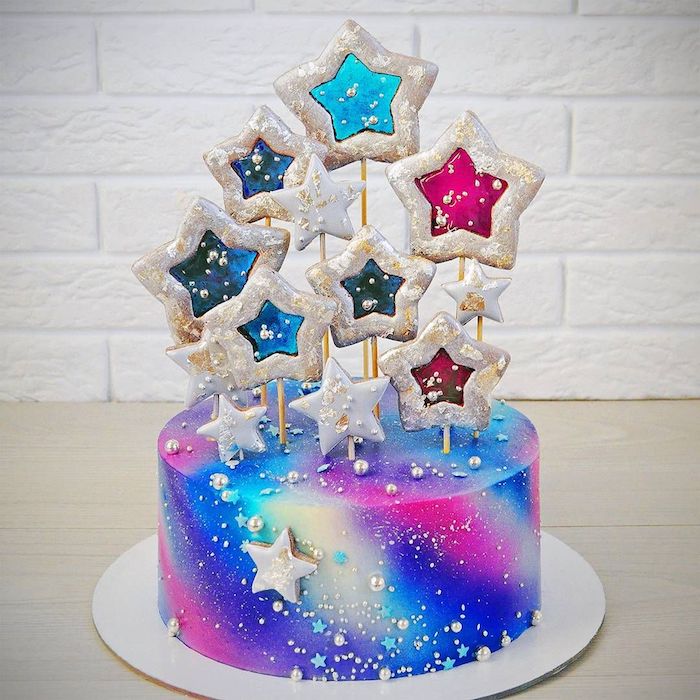 biscuits en forme d etoiles pour decorer un cake galaxy arc en ciel au glaçage blanc, rose, bleu marine et bleu clair