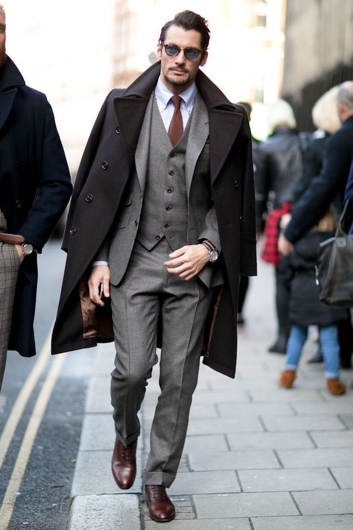 Manteau long noir, costume gris trois pièces, chemise bleu claire, cravate brune, comment bien s'habiller classe, tenue homme chic casual