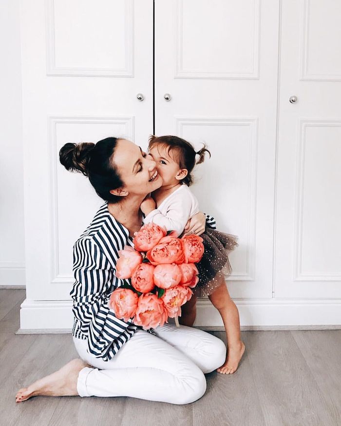 Mere fille photo bisou, bouquet de fleurs pivoines rouges, idée tenues coordonnées pour la mère et son bébé en blanc et bleu 